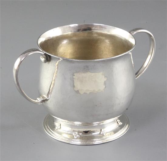 A George V Arts & Crafts silver two handled cup, Width to handles 5”/128mm Height 3”/78mm Weight 7oz/197grms